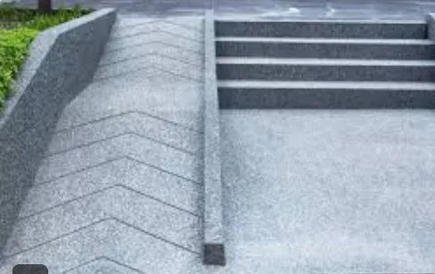 Wide grey stone steps with a sloped ramp beside them.