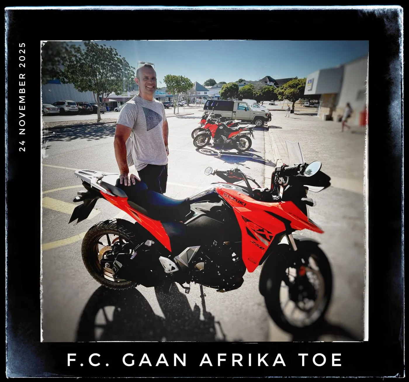 A person stands beside a red motorbike on a street, captioned 24 November 2025 and F.C. gaan Afrika toe.