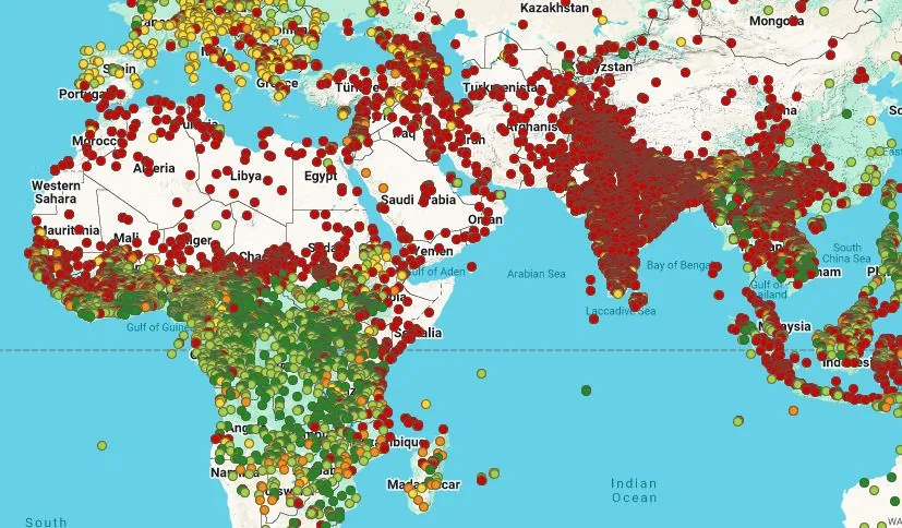 A world map covered with red, orange and green dots.